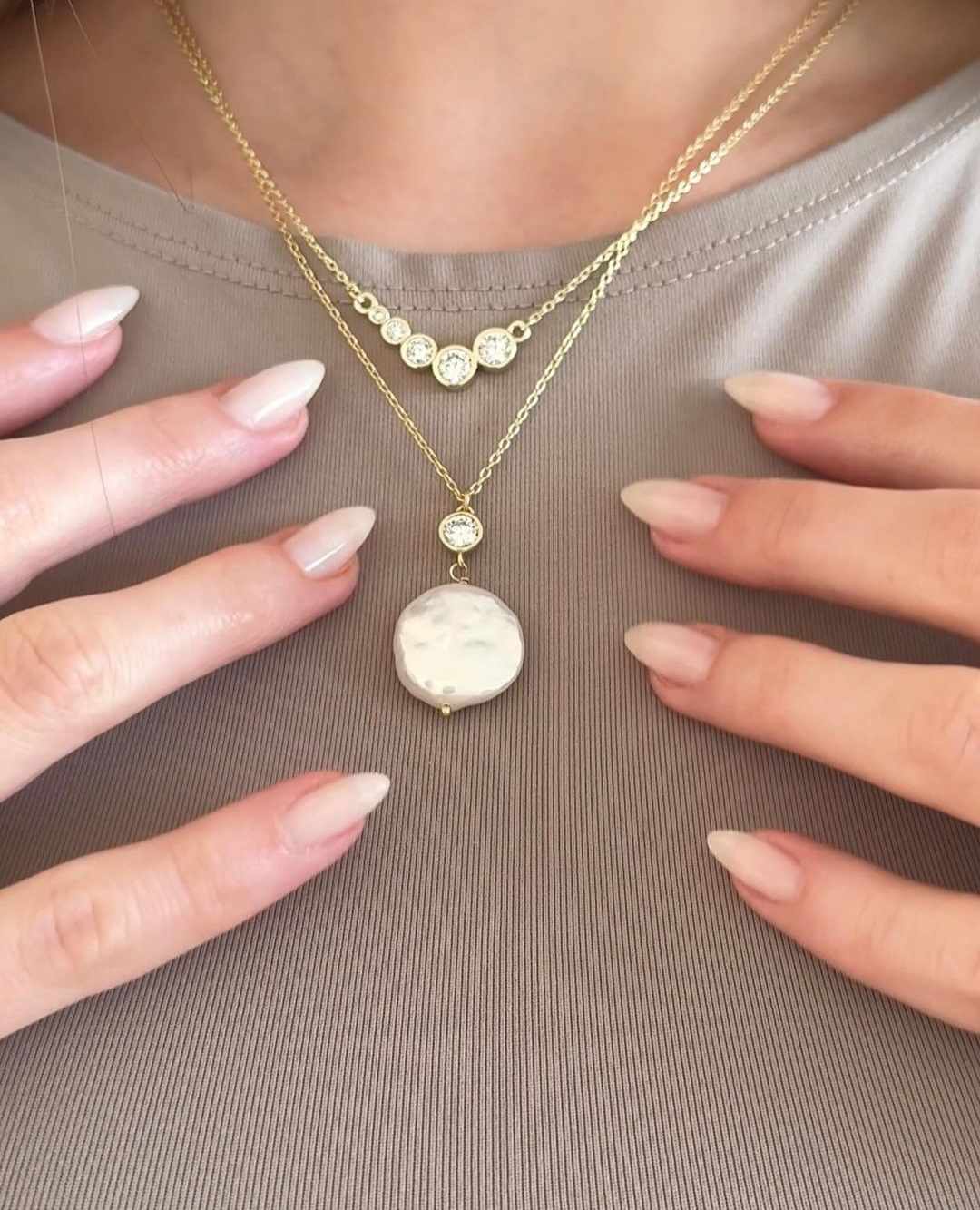 Avi Jewels halskæder — lagvise forgyldte kæder med zirkonia og perleskive-vedhæng