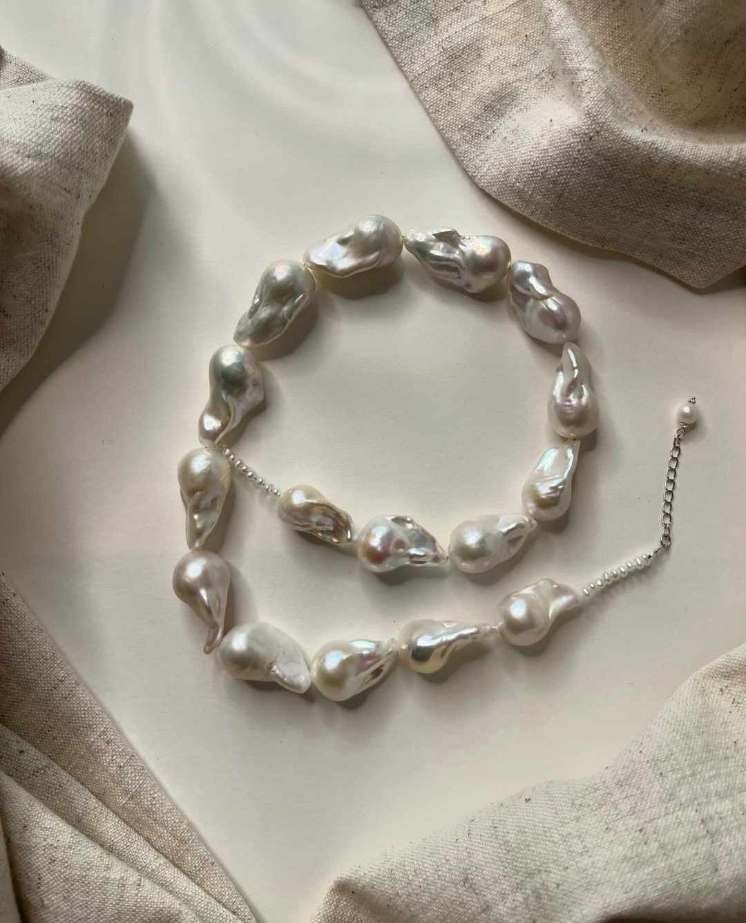 Avi Jewels armbånd — barokke ferskvandsperler på fint sølvkæde arrangeret på lærred