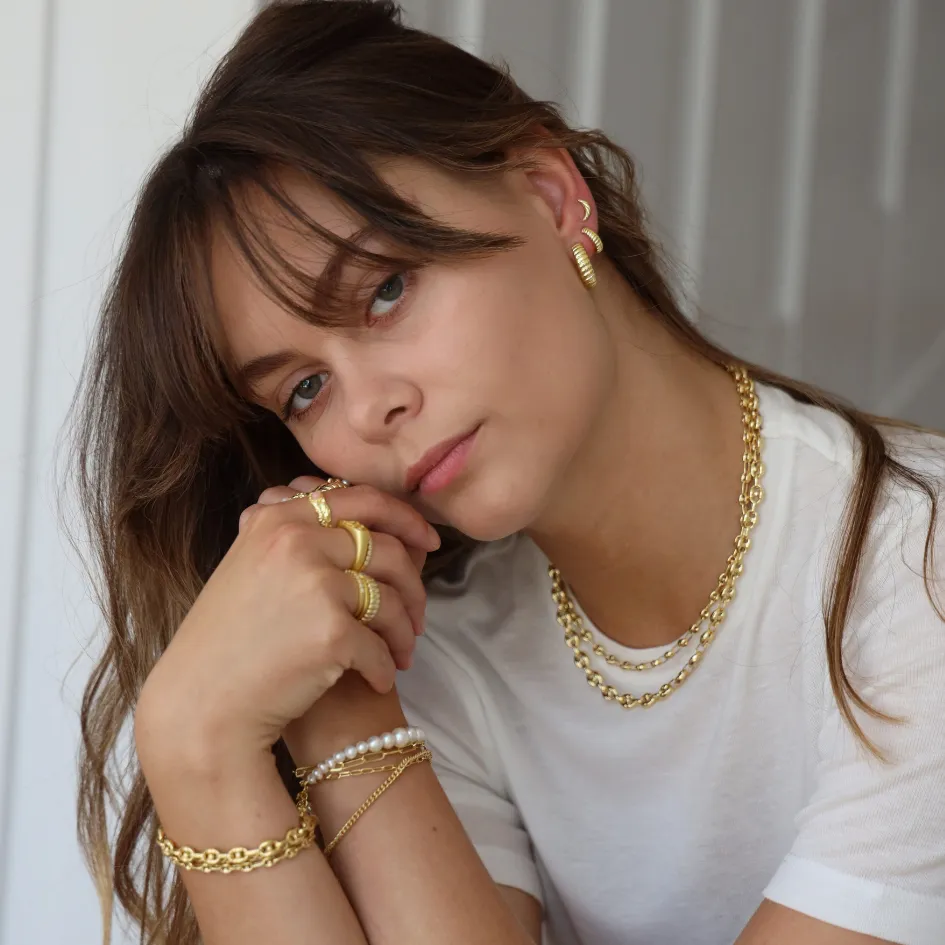 Aqua Dulce lookbook — model med forgyldte kæder, perlearmbånd og ringe