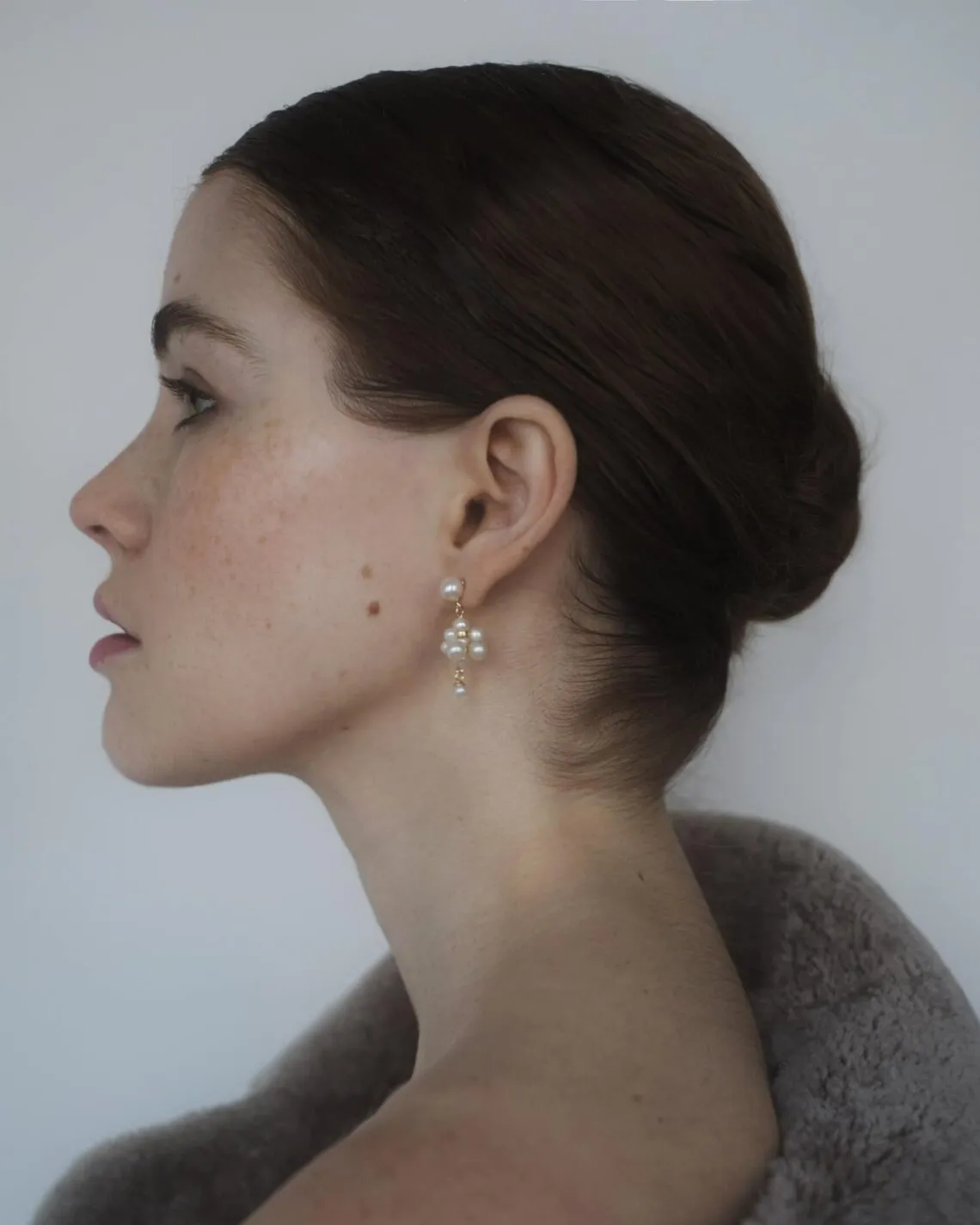 Avi Jewels Annas ørering med runde, naturligt hvide kultur ferskvandsperler båret af model i profil